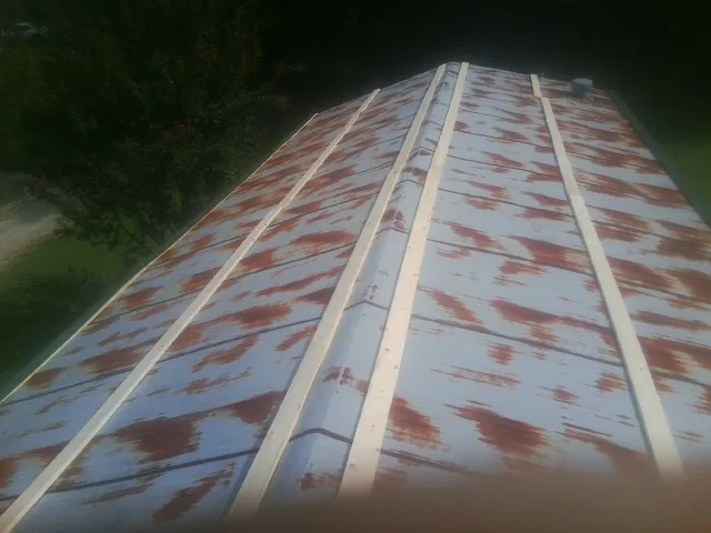 Rusted metal roof panels with new wood purlins before replacement — Storm Damage Roof Repair in Keego Harbor by Roofing Brothers