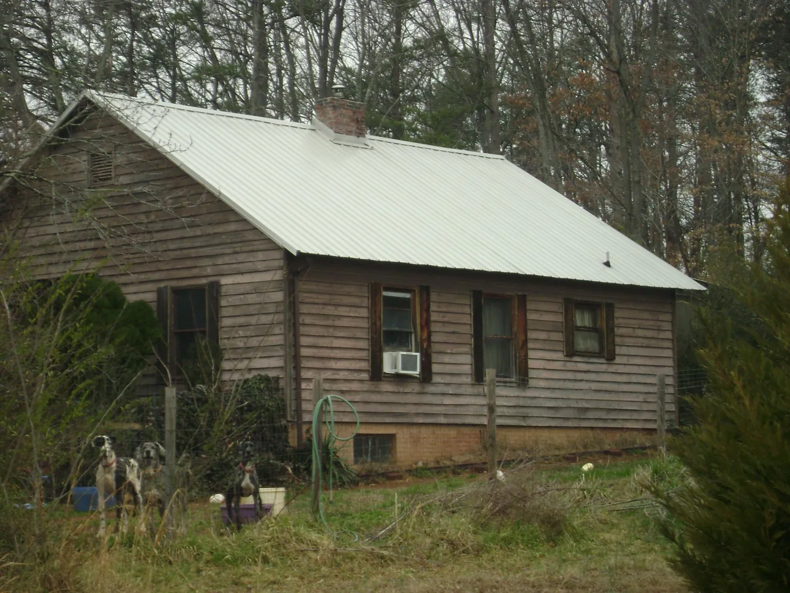White metal roof on an old wood sided farmhouse, from a Metal Roof Installation job in Keego Harbor